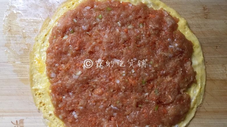 如意鸡胸肉蛋卷,蛋皮摊好后,放在案板上,把剁好的鸡肉均匀摊在蛋皮上