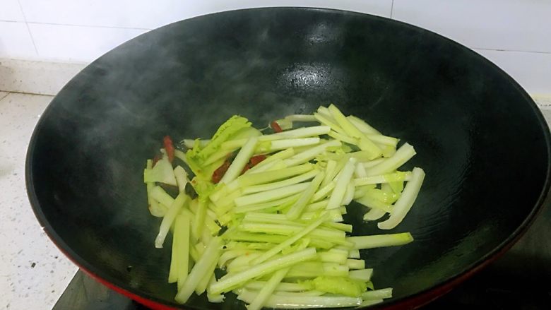大白菜炒粉条,倒入白菜根部,炒几下使白菜瘪下去。