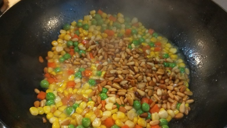 松仁玉米 新文美食,最后倒入松仁炒均匀即可出锅。
