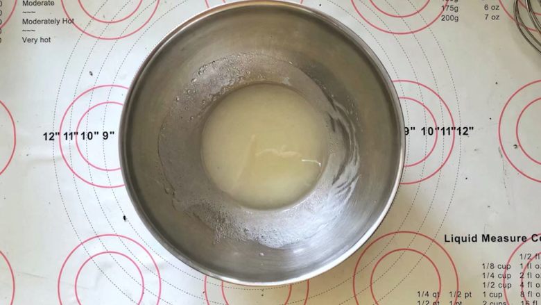 黑米杯子蛋糕,6、把玉米油和水倒入盆中,用蛋抽搅打至乳化状态。