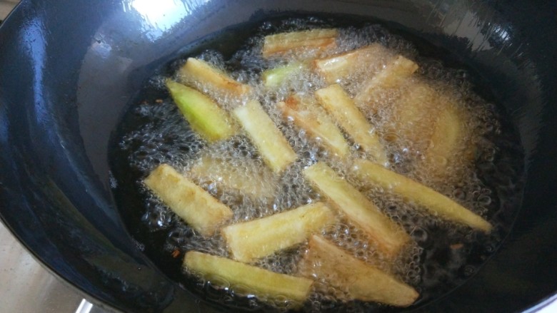 鱼香茄子 新文美食,锅中倒油烧七成热倒入茄子条。