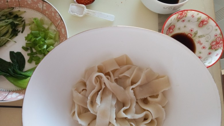 家常油泼扯面,面条控水装入大碗放入<a style='color:red;display:inline-block;' href='/shicai/ 788'>生抽</a>,醋,盐,码上油菜,黄瓜丝,葱粒