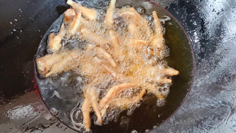 虎皮凤爪,接着起锅倒入适量油,5成热时倒入晾干的鸡爪