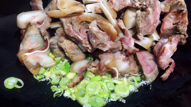 #猪年#回锅猪头肉,油锅烧热,放入肉块和葱碎翻炒片刻