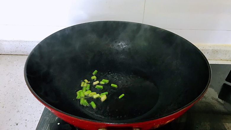 茄汁花菜,热锅中放油,葱根部放入,炒出香味。