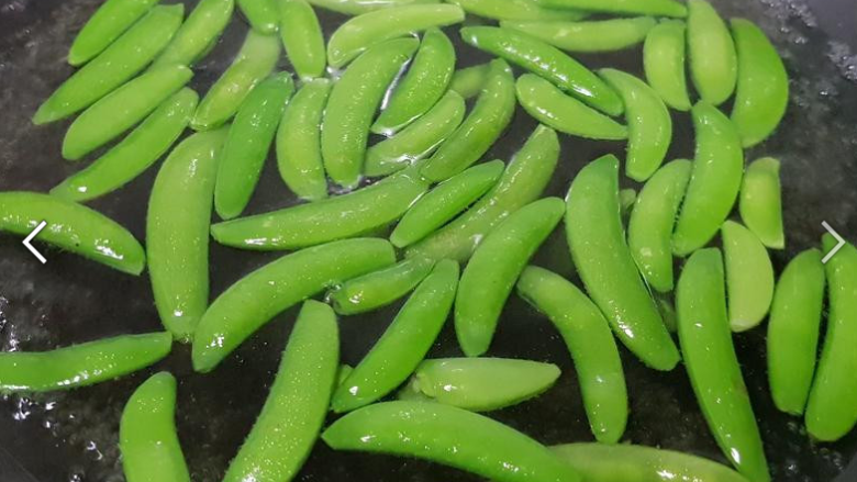 甜豆炒鱿鱼,煮半锅水,煮滚后,加入少许油及盐巴(食材外),将甜豆烫熟备用。