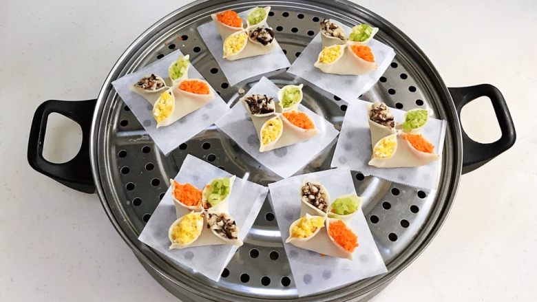 四喜蒸饺,包好的饺子依次摆入蒸屉上,记得要垫油纸或蒸布。