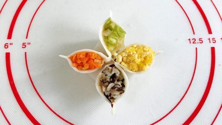 四喜蒸饺,依次填入香菇、胡萝卜、芹菜和鸡蛋,然后捏出个尖角。