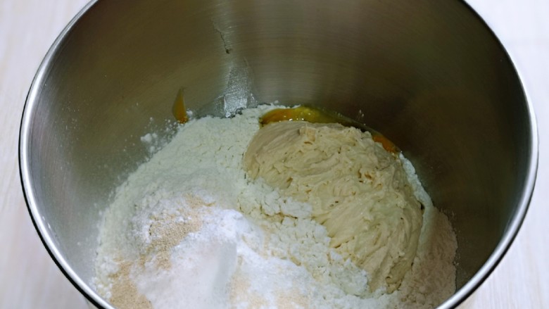 松软老式小面包,把面团的所有食材加入厨师机桶中,先液体再粉类的顺序加入,再加入酵母粉,最后加入波兰种,启动1档,揉面10分钟。