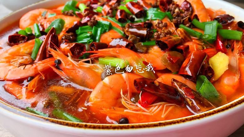 水煮香辣虾,把煸炒好的辣椒和油一起浇到虾上面即可。美味的水煮虾做好了,香辣开胃,特别好吃。