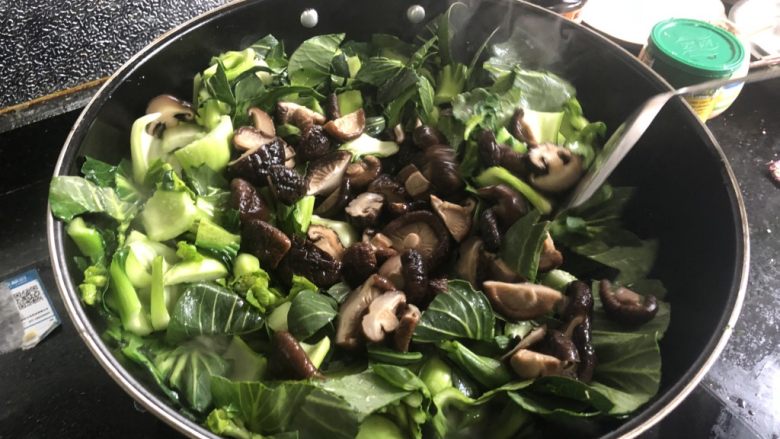 香菇炒青菜,翻炒几下以后加入香菇,加大约2茶匙盐,盐可以少量多次添加,根据菜量适量增减。