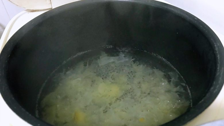 马蹄银耳红枣汤,电饭煲中加入原材料四倍水,水要一次加足,不要中途加水。按煮汤按钮,将银耳倒进锅中。