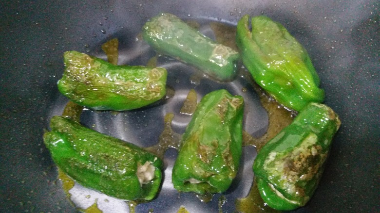 虎皮青椒酿肉,锅内放油烧热,再把包有肉的青椒放入油锅内煎。记得要勤翻面哦!