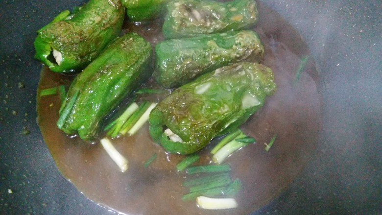 虎皮青椒酿肉,看青椒几面都煎出虎皮后,就把调好的酱汁倒入锅内,转中火烧两分钟,加入葱段,出锅喽!
