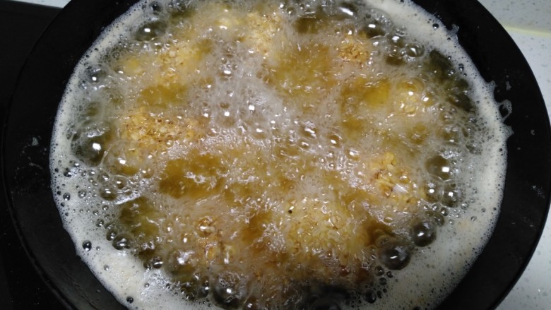 炸燕麦鸡翅根,再均匀粘上燕麦片,锅中倒入适量花生油,油温5层热,放入鸡翅根小火炸至微黄。