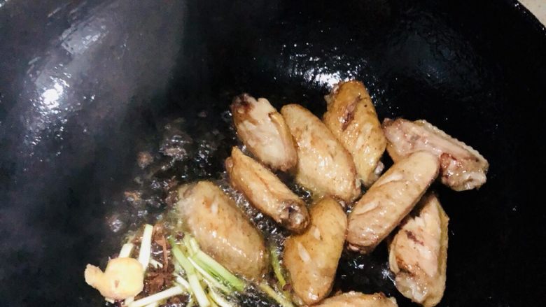 可乐鸡翅,中火,两面煎至上图金黄颜色后,倒入切好的葱头,花椒等材料