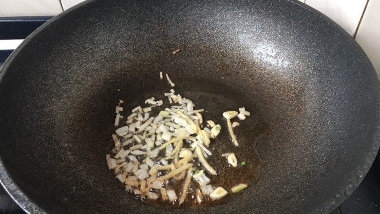 官烧目鱼条(天津菜),原锅留有少许余油,回火,小火爆香葱丝、姜丝、蒜片。