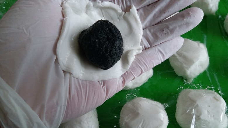 黑芝麻汤圆,拿一个面团在手心按扁,放上芝麻馅儿,包好捏紧收口!再搓圆,依次做好。吃不完的汤圆放冷冻室冻起来,想吃的时候便拿出来煮,无需解冻!