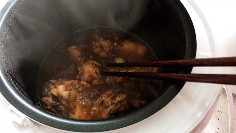 可乐鸡根翅(电饭煲版),约摸15分钟左右的样子,打开锅盖,用筷子把鸡根翅翻个面,然后盖上锅盖继续煮