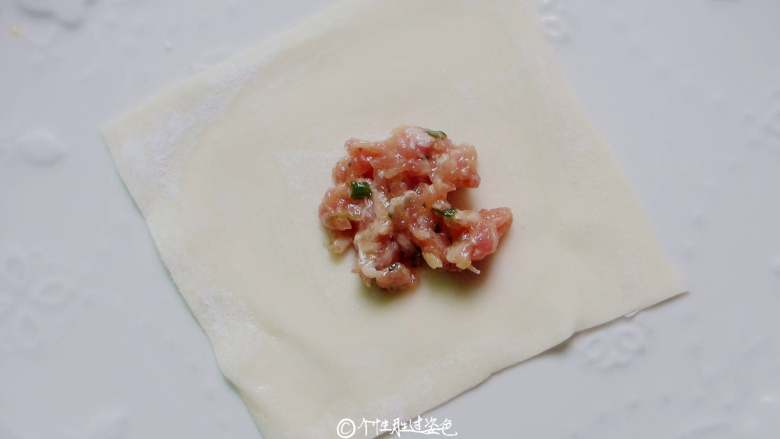 酸辣馄饨,开始包馄饨,一张<a style='color:red;display:inline-block;' href='/shicai/ 4453'>馄饨皮</a>放入适量的肉馅。