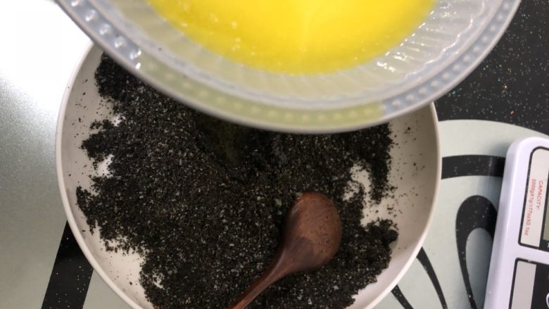 芝麻流心汤圆,黄油隔水融化成液态后少量多次加入蛋白糖芝麻粉中,搅拌均匀。