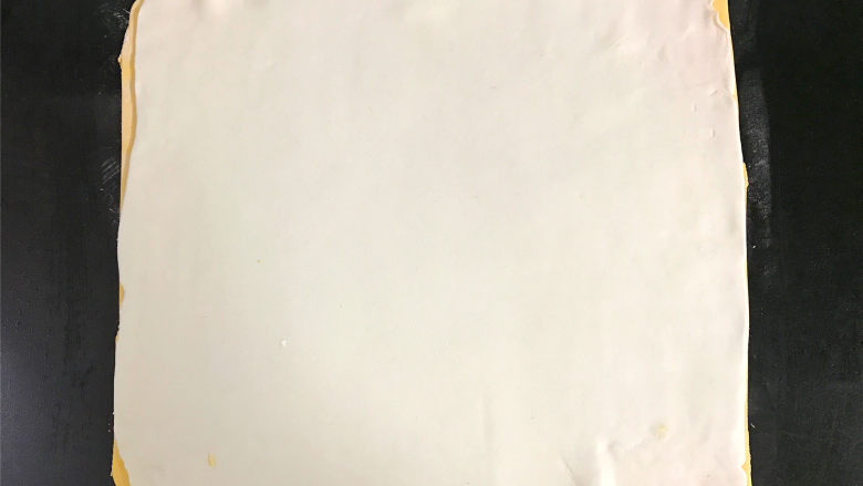 双色汤圆,南瓜粉团同样擀成正方形的薄片后,叠在白色面片上。