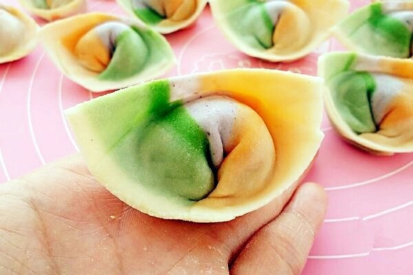 彩虹馄饨(宝宝超爱吃),把下面两个角往里带捏在一起,馄饨就包好了。