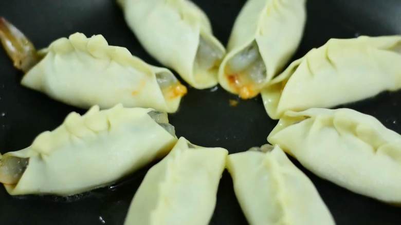 鲜嫩多汁的大虾抱蛋煎饺,你一定得试一下,冷锅冷油,摆入饺子,中火煎至底部金黄,倒入半碗清水,加盖焖5分钟。
