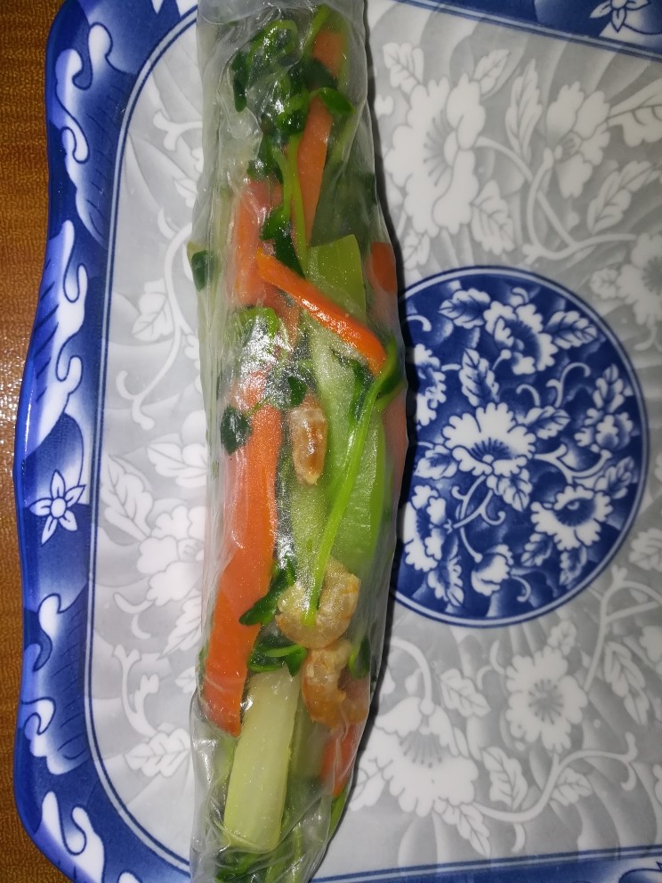 这样一款清新亮丽的春卷,发在朋友圈,好评如潮,可以诱惑无数人,稍稍用力,卷成圆筒模样,如图所示,就做好一个非常好看的越南米纸了。