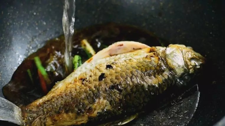 教你“葱烧鲫鱼”的做法,非常美味的家常菜,.放入鲫鱼,加入料酒、老抽、白糖、清水