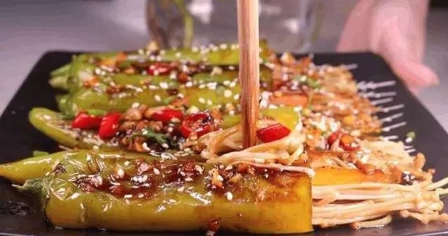 青椒金针菇,上桌前再撒上一些炒香的白芝麻,如图一道改进版的青椒酿金针菇就做好啦。