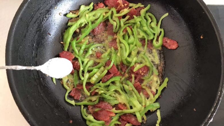 尖椒炒腊肠,倒入适量的盐，翻炒几下就可以出锅了