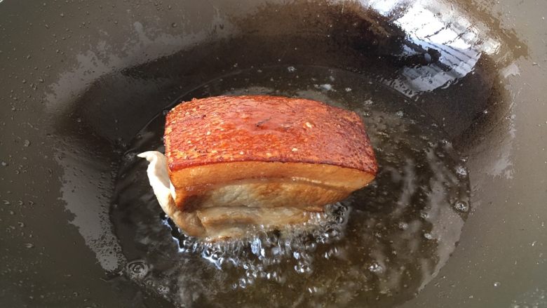 #猪五花# 金牌天津扣肉,在锅里倒入适量的油,油五成热时,放入五花肉,肉皮朝下,炸至金黄色,肉皮爆起后捞出备用。
