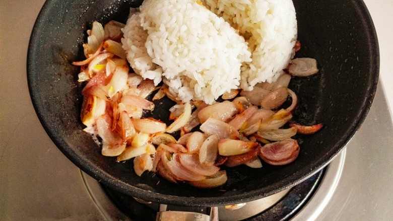 什锦咖喱焗饭,留底油。放入切好的洋葱炒出香味,炒至金黄色时,加入米饭。继续翻炒。