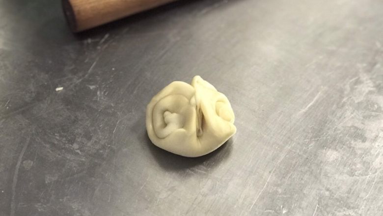 白皮酥,完成馅料后继续处理面皮:将刚才的卷卷收口朝上,用筷子在中间压一下,把两头往中间并拢。