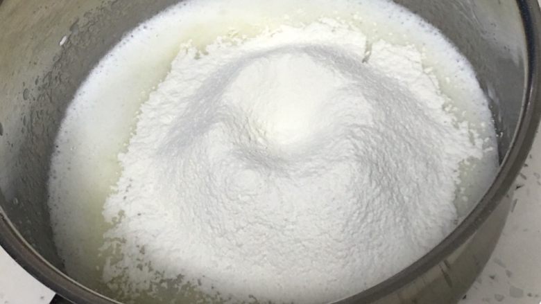 肉松小贝蛋糕,搅拌至油和牛奶混合,过筛低筋粉。