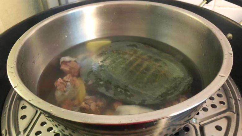 清炖甲鱼汤,蒸锅放入适量水烧开,放上蒸架,把甲鱼放到蒸架上,盖上盖子,大火蒸5分钟转中火炖30分钟。