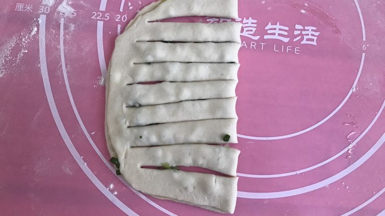 发面葱油饼,饼皮对折,切成均等的条状。