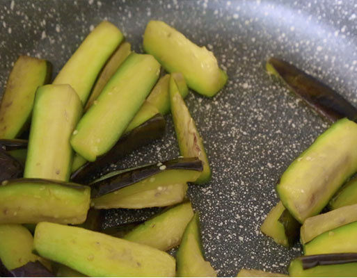 铁板茄子,锅烧热倒入适量的油,放入长茄翻炒,炒至变色捞出来;