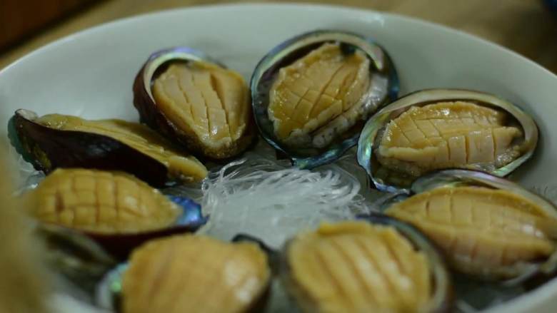 蒜蓉粉丝蒸鲍鱼,这一桌撑台面就靠它了,提前泡软的粉丝铺在盘底再摆上鲍鱼。