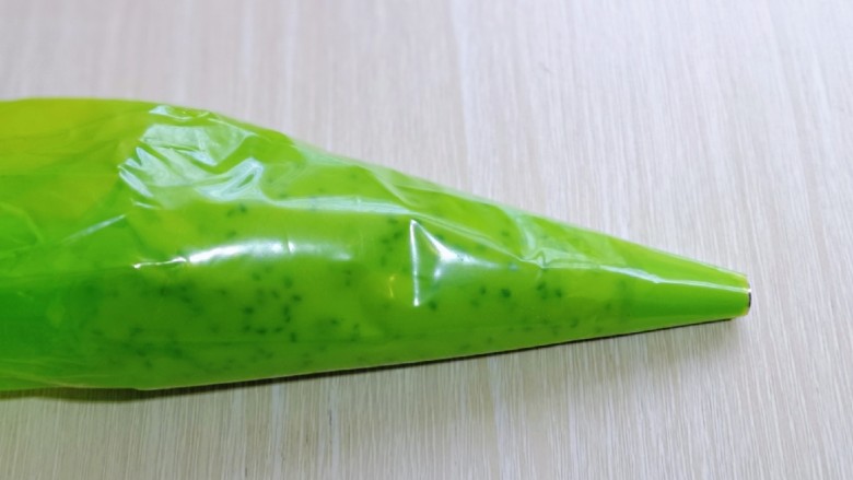 黑芝麻麻薯面包,将拌好的麻薯糊放入裱花袋,先装上圆的裱花嘴,不装也可以。(裱花袋最好使用橡胶的,面糊比较干,挤的时候需要用力,不然裱花袋容易破)