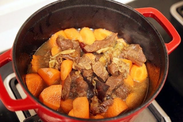 红焖羊肉,把切好的胡萝卜块放入锅中,再放入两勺盐调味。然后盖好锅盖,继续炖15分钟左右。