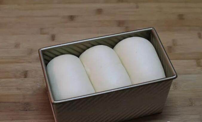 鲜奶高蛋白吐司,在温暖湿润处(温度38度,温度80%左右)进行二次发酵;面团发到模具的八九分高(如果做带盖吐司,七分高即可),手指轻按后略有弹性即可进行烘烤。