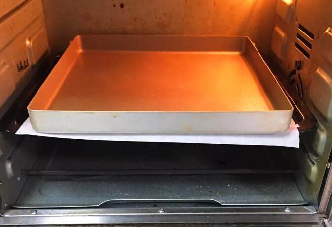 南瓜豆沙味喜饼,烤箱预热至175度,烤盘送入烤箱中层烤制6分钟定型。