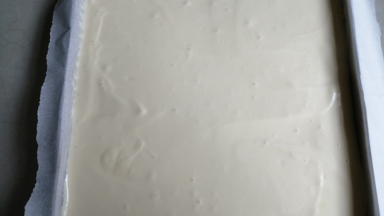 香葱肉松蛋糕, 正方形烤盘铺一张油纸,把蛋糕糊倒入,抹平表面,在桌面上震出气泡