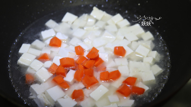 虾仁豆腐,然后加入适量的清水,胡萝卜盖上锅盖煮开,水开后调中小火煮5分钟。