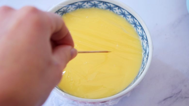 肉末水蒸蛋,盖上保鲜膜,用牙签在保鲜膜上扎几个小眼