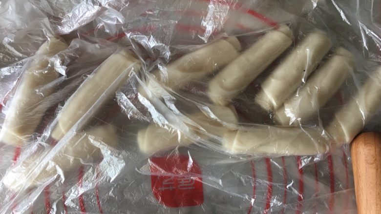 蛋黄酥(肉松麻薯蛋黄馅),将包裹好的油酥面团按扁擀成长舌状后卷起来盖保鲜膜静置20分钟