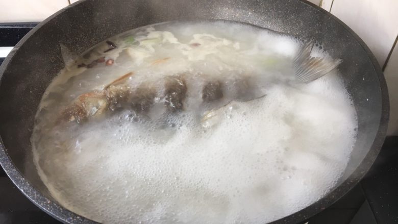 鲫鱼炖豆腐,大火煮开,中火熬至汤色变白。