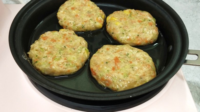 鸡胸蔬菜饼,平底锅中倒少许的油,放入做好的小饼,小火煎至微黄,喜欢外壳硬一点的就煎至金黄